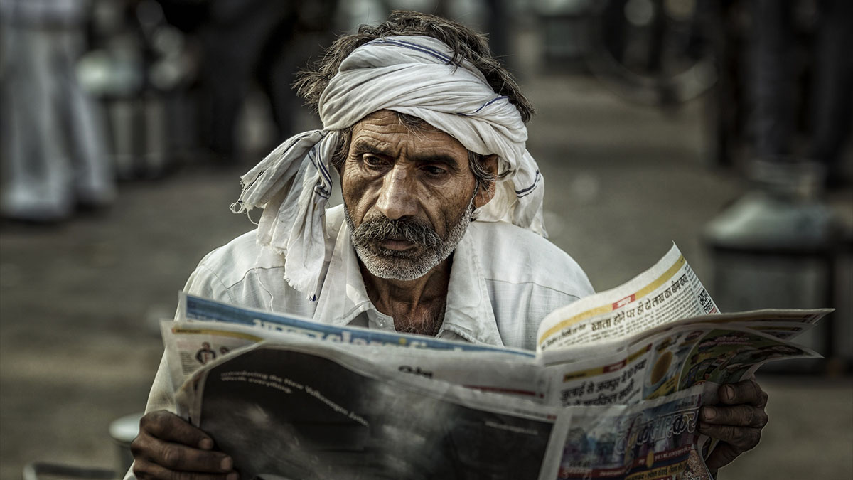 old man reading paper